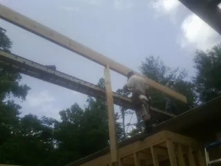 Carpenter setting a ridge beam over a new addition frame — Ice Dam Removal by Roofing Brothers in Georgiana