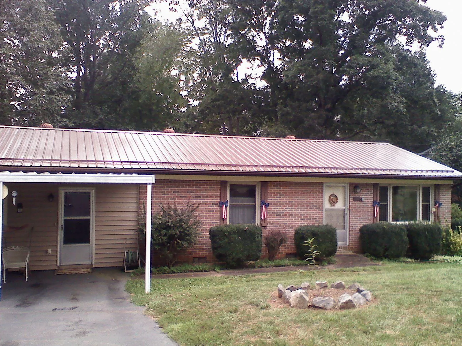 Bronze metal roof and carport on a brick ranch home — Roof Repair work by our crew in Georgiana
